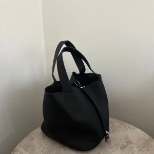 Svart skinnväska med lås - Helt ny skinnväska, svart med silverdetaljer 