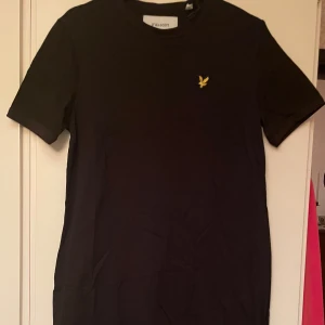 *NY*Svart t-shirtklänning stl 10 (38/40) från Lyle & Scott, presenttips  - T-shirt dress Jet Black. Ny oanvänd, lite rakare modell, fin kvalitet. Passar bäst på M, uppskattar till 38/40 (engelsk size 10). Material: 100% ekologisk bomull.   Nypris: 399 sek, Pris nu: 180  sek