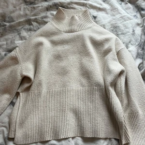Beige polotröja från Gina Tricot - Mysig beige polotröja från Gina Tricot med ribbade detaljer vid krage och nederkant. Säljer för jag har tröttnat på den