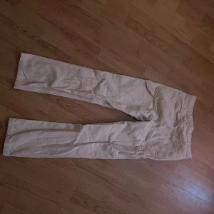 Beige byxor - Snygga beige byxor med rak passform. Perfekta för en avslappnad stil. De har en klassisk design med fickor och bälteshällor.