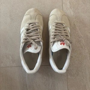 Beige Adidas Gazelle sneakers - Säljer ett par stilrena beige Adidas Gazelle sneakers. Använda men i mycket gott skick! Se bilder för slitage💖storlek 37 1/3