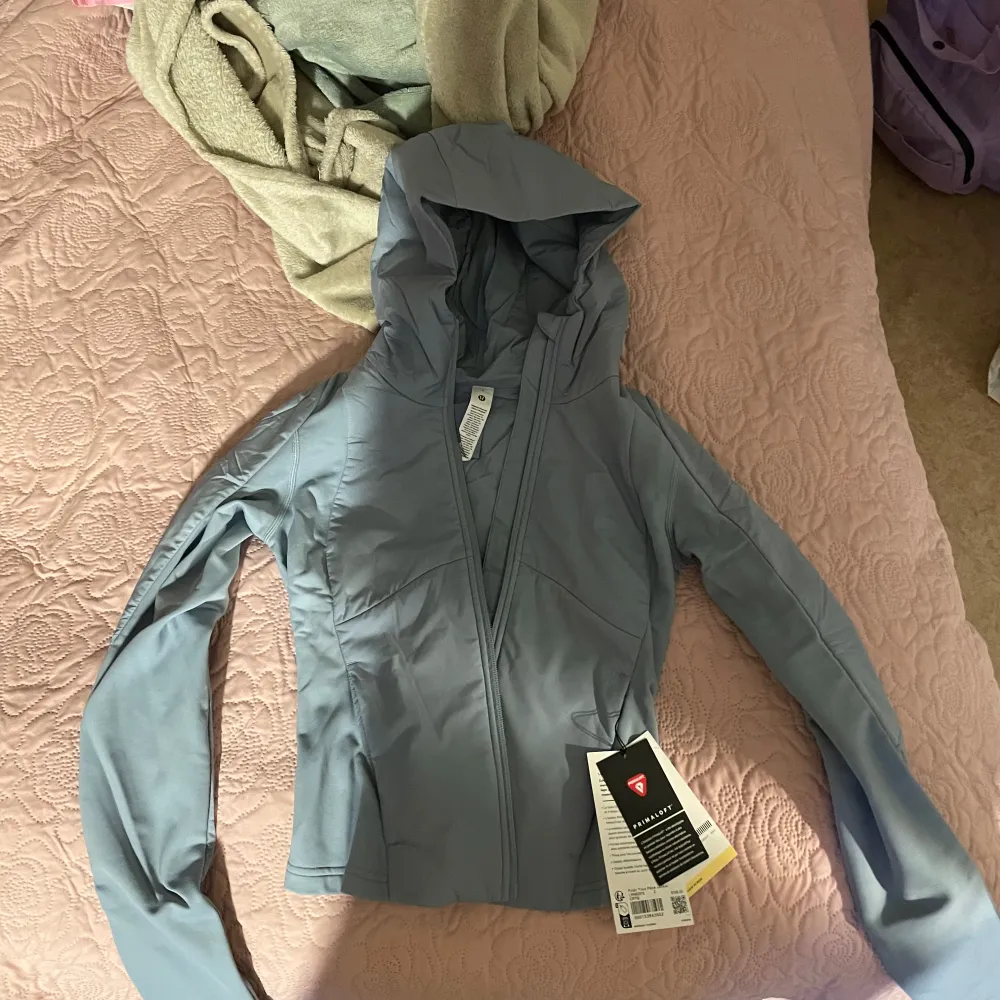 Säljer en snygg ljusblå jacka från Lululemon med huva och dragkedja. Jackan har en figurnära passform och långa ärmar, perfekt för träning eller en aktiv livsstil. Den är tillverkad i ett lätt och bekvämt material som andas. Perfekt för dig som vill ha stil och funktion i ett! Storlek passar XS aldrig använd Köpt för 1800kr . Takit.