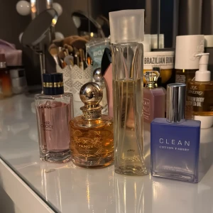 Parfymer från La Rive, Fancy, Clean och en annan - Säljer en samling parfymer inklusive La Rive Her Choice med en rosa ton, Fancy med en elegant rund flaska och guldlock, samt Clean Cotton T-Shirt i en fyrkantig blå flaska. Perfekt för den som vill ha variation i sin doftgarderob. Köp alla för 350kr eller: her choice 50kr. Fancy 100kr. Secrets by dana 50kr. Clean 200kr (nästinstill oanvänd, 60mlkr