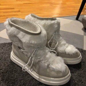 Vita pälsfodrade boots - Säljer ett par vita boots med pälsfoder och snörning. Perfekta för kalla dagar med sin varma och mysiga design. Köpt dessa från zalando märket tamaris. Köpte för ca 1000kr och har endast använts ett fåtal gånger. Är i storlek 40🫶🏻