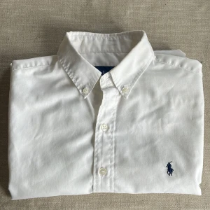 skjortor från Ralph Lauren - Säljer två stilrena skjortor från Ralph Lauren. En vit och en ljusblå, båda med knappar och den ikoniska broderade loggan på bröstet. Perfekta för en elegant look. 400.- för båda eller 250.-/st storleken är ’barn L’ men är bärs av dam S och söner stl 158-170. 