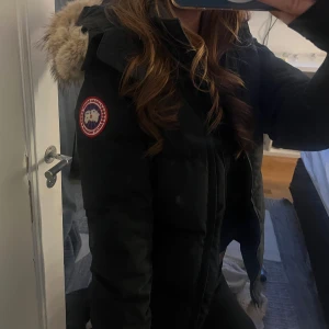 Svart dunjacka med päls från Canada Goose - Säljer en svart canada goose jacka, modellen är Chelsea parka. Väldigt fin och varm vinterjacka.