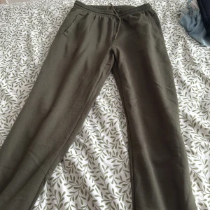 Gröna mjukisbyxor - Säljer ett par bekväma gröna mjukisbyxor med elastisk midja. Perfekta för en avslappnad dag hemma eller en promenad i parken. Byxorna har en enkel design utan mönster och är gjorda i ett mjukt material.