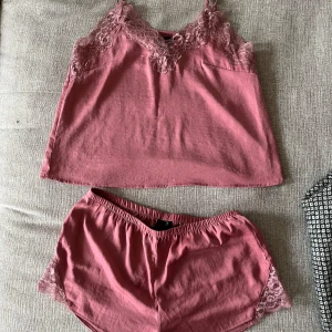 Pyjamasset, H&M, S, rosa - Rosa pyjamasset (linne+shorts) med spets från H&M i storlek S. I mycket fint skick, som ny då använt max 2 ggr. 100% polyester.   Mått linne:  Längd ca 55 cm enligt bild (justerbar till mer/mindre)  Byst ca 45 cm Midja ca 48 cm  Mått shorts: Inre längd ca 5 cm Yttre längd ca 24 cm Midja ca 35 cm (elastisk)  Stuss ca 43 cm