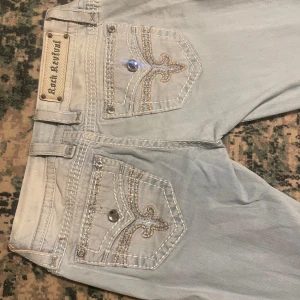  Rock Revival jeans - Snygga ljusblå jeans från Rock Revival. Byxorna har lite smuts på knäna men från de är dom skit snygga! Va skinny jeans från början men sydde ut dom med vitt jeans material. Strl 26. Behövde tyvärr sälja dessa eftersom de sitter för tight på mig