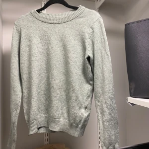 Grön stickad tröja från VILA - Säljer en mysig grön stickad tröja från VILA. Tröjan har en rund halsringning och långa ärmar med ribbade muddar vid ärmslut och nederkant. Perfekt för kyligare dagar!