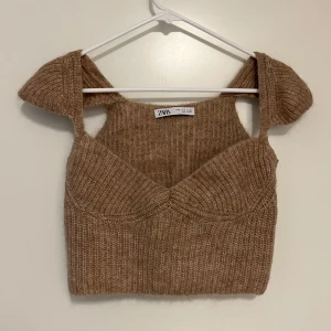Stickad topp  - Säljer en croppad beige stickad topp från Zara. Den är väldigt mjuk och mysig samtidigt som snygg. Supersöt verkligen, har använts en del men fortfarande i bra skick
