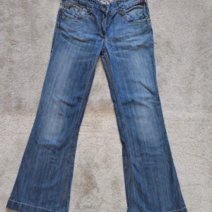 Blå bootcut jeans - Supersnygga och är i jättebra skick! Innerbenslängd: 80cm Total längd: 103cm Midja: 38cm Midjehöjd: 20cm