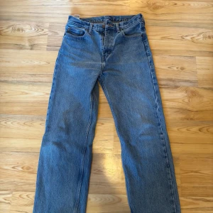 Blå jeans från Levi's - Klassiska blå jeans från Levi's med rak passform och fem fickor. De har en traditionell design med knappgylf och bälteshällor. Perfekta för en avslappnad stil.