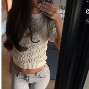 Vit stickad kortärmad tröja - Säljer en söt vit stickad tröja med korta ärmar och ett fint hålmönster. Tröjan är använd fåtal gånger med inga deffekter 