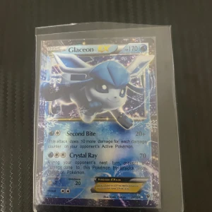 Glaceon EX Pokémonkort - Säljer ett Glaceon EX Pokémonkort med 170 HP. Kortet har attacker som Second Bite och Crystal Ray. Det är i en skyddande plastficka och har en isblå design med Glaceon i fokus. Perfekt för samlare eller Pokémon-entusiaster!