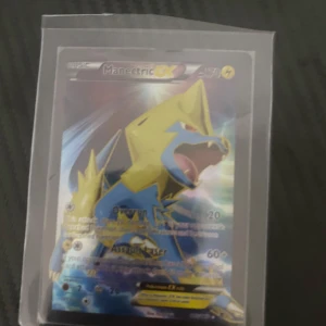 Manectric EX Pokémonkort - Säljer ett Manectric EX Pokémonkort med holografisk design. Kortet har attacker som Overrun och Assault Laser. Perfekt för samlare eller spelare som vill stärka sin kortlek med en kraftfull Pokémon.