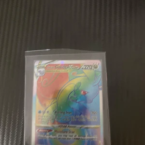 Hisuian Goodra VSTAR Pokémonkort - Säljer ett Hisuian Goodra VSTAR Pokémonkort med en holografisk design. Kortet har en färgglad bakgrund med Hisuian Goodra i fokus och har 270 HP. Perfekt för samlare eller spelare som vill stärka sin kortlek.