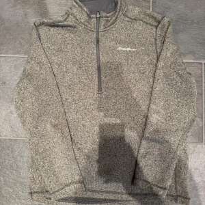 Eddie Bauer tröja - En Eddie Bauer hoodie i grön/grå färg. Väldigt likt Patagonia fast för en mycket billigare peng. Storlek L/XL. Väldigt bra skick, använd fåtal gånger. Mått: bröst:60, axelbredd:49, längd:73, armlängd:66. För frågor och bilder, kontakta mig!