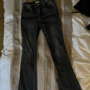 Svarta bootcut jeans från Gina Tricot - Snygga svarta bootcut jeans från Gina Tricot. De har en klassisk femficksdesign och stängs med dragkedja och knapp. Perfekta för en stilren look.
