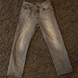 Grå Levis 501 jeans - Säljer ett par klassiska grå Levis 501 jeans i fint skick. De har en rak passform och är tillverkade i slitstarkt denim. Storleken sitter som 28x28. 
