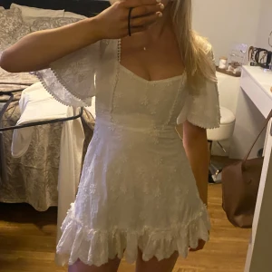 Studentklänning showpo showpoo / Vit klänning med volangdetaljer - Charmig vit klänning med kort längd och volangdetaljer. Klänningen har kortärmade ärmar och en söt, romantisk stil. Perfekt för en student eller någon annan festlighet i sommar!                                                     !!en sak som kan vara värt att tänka på är att den äinte ät så rymmig (den är ganska tajt vid brösten) tyvärr. Jag gör inga returer heller💓🌸🙏🏼!!