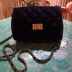 Svart quiltad axelväska i skinn (Verapelle) - Snygg svart quiltad axelväska i  skinn med guldfärgad kedja och spänne. Tillverkad i Italien, perfekt för att ge din outfit en lyxig touch. Väskan har en praktisk dragkedja inuti för säker förvaring. Priset kan alltid diskuteras!!❤️❤️