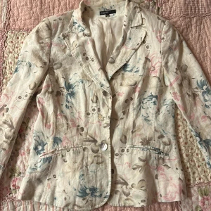 Blommig kavaj från KappAhl - Säljer en elegant blommig kavaj från KappAhl i storlek 40. Köpte den second han men är nästan som ny - det enda är att ena knappen har gått sönder men det är en lätt fix. Skönt tunnt tyg 