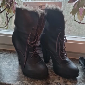 Gråa boots med pälsfoder och snörning - Gråa boots i veganskt skinn och foder i fejkpäls. Liten dold platå och tjocka klackar gör dom enkla och stabila att gå i. De är från 2010-talet men bara avända en så de är i gott skick! Inga synliga fläckar eller skador. 