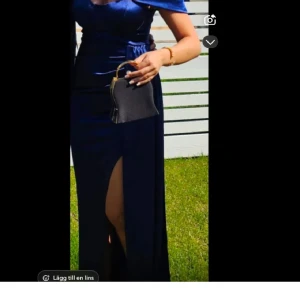 Mörkblå långklänning med slits - Elegant mörkblå långklänning i satin med en djärv slits framtill. Klänningen har en offshoulder-design som ger en sofistikerad look. Perfekt för speciella tillfällen. Jag har köpt den av en annan säljare på plick (säljer för samma pris)men den passade inte min överkropp annars var den jätte bra. Perfekt för bal!