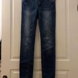 Blå jeans från Rut&Circle - Snygga blå jeans från Rut&Circle i en klassisk design. De har en knapp och dragkedja framtill samt fickor både fram och bak. Perfekta för en avslappnad stil.Storlek 34