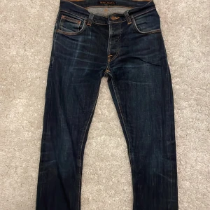 Mörkblå jeans från Nudie Jeans - säljer ett par mörkblåa nudie jeans i storleken w28 l32 jeansen har en cool wash och är i passformen slimfit 
