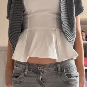 Grå stickad kofta från H&M - Säljer en stilren grå stickad kofta från H&M🩷. Koftan har korta ärmar och en öppen design med ribbade kanter. Perfekt för lager-på-lager och att hålla sig varm under kyliga dagar💞. Skriv vid frågor eller intresse💕