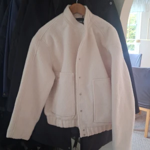 Vit/benvit jacka - Den är mer vit/naturvit/benvit i verkligheten. Den ser rosa ut men den är inte rosa. Skulle säga att den är lite liten i storlek. Aldrig använd med lapp kvar