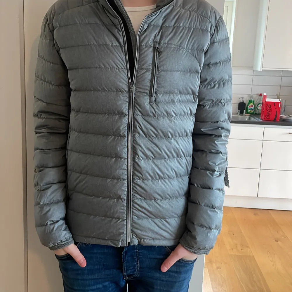 Säljer en stilren grå dunjacka från Volt. Jackan har en dragkedja framtill och en praktisk bröstficka med dragkedja. Perfekt för kyligare dagar med sin quiltade design som håller värmen. Passar bra till jeans eller andra casual outfits. Pris går att diskutera. Storlek L men passar även M. Nypris 1499.. Takit.