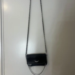 Svart axelväska från Zadig & Voltaire - Svart zadig & voltaire väska rock nano. Endast använd ett fåtal gånger. Höjd: 12cm, Längd: 17cm. Pris går att diskutera!