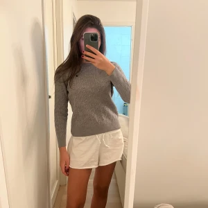 Grå stickad tröja - Säljer en supermysig grå stickad tröja med kabelstickat mönster. Perfekt för kyliga dagar och passar både till vardags och lite finare tillfällen. Tröjan har långa ärmar och en klassisk passform. Ett måste i garderoben för höst och vinter! 🍂❄️