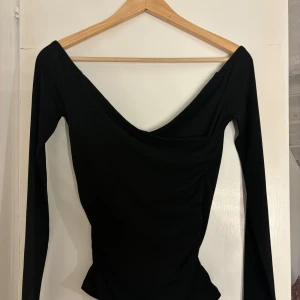 Urringad tröja bikbok  - Jättefin svart långärmad topp med urringning. Den är från bikbok och i storlek xs men funkar även på s. Inga skador eller liknande och endast använd 1 gång☺️