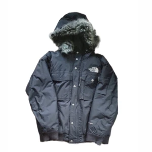 The North Face parka Gotham - En riktigt fet vintage The North Face Gotham parka med pälsluva. Väldigt bra skick,  men en knapp vid dragkedjan fungerar ej och den saknar en fickknapp (se bilden). Varm och skön med dun inuti så riktigt varm. Sitter riktigt snyggt. Storlek L. Skriv för frågor och vid intresse