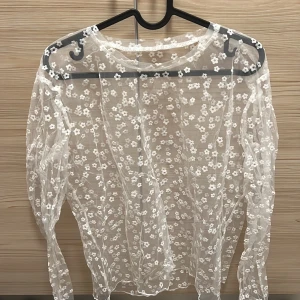 Vit blommig meshtröja - Säljer en superfin vit meshtröja med blommigt mönster. Den är perfekt för lager-på-lager och har långa ärmar!
