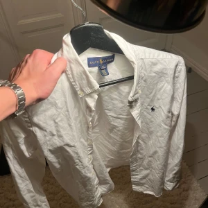 Vit skjorta från Ralph Lauren - Säljer en stilren vit skjorta från Ralph Lauren i storlek xs. Skjortan är bara använd ett fåtal gånger och skicket är 10/10. Säljer pga att det är för liten storlek. Skriv vid frågor, pris kan diskuteras vid snabb affär!