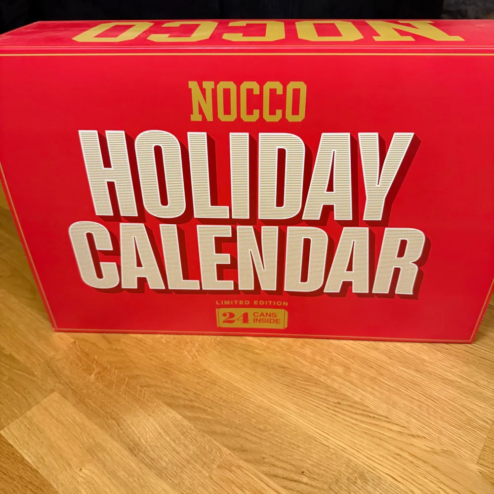 Säljer en NOCCO Holiday Calendar i en snygg röd färg. Denna limited edition-kalender innehåller 24 burkar, perfekt för att räkna ner till julen med en ny smak varje dag. Kalendern är stor och rektangulär, vilket gör den till en perfekt present eller för att unna sig själv något extra under högtiden.. Övrigt.