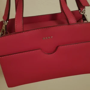 Väskor  - Jag säljer min fina axelväska DKNY bra skick använd 2gånger Inga skador ej smutsig, men stått i garderoben ett bra tag,,,Hör av dig vid intresse,,,