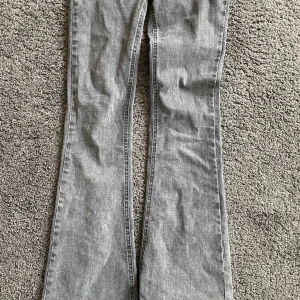 Grå bootcut jeans - Säljer ett par grå bootcut jeans i bra skick. De har en klassisk femficksdesign och är perfekta för både vardag och fest. Jeansen har en snygg tvättad look och är gjorda i ett bekvämt material som passar till alla tillfällen.