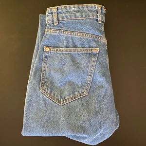 Mörkblå jeans - Mörkblå jeans med konstgjorda märken. 