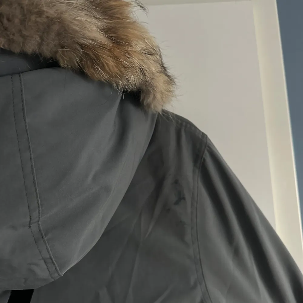 Säljer en grå parkajacka från Canada Goose i mycket bra skick. Jackan är perfekt för kalla vinterdagar med sin långa design och varma foder. Den har långa ärmar och praktiska fickor framtill. Stängs med både dragkedja och knappar för extra skydd mot kyla. Perfekt för vintern! ❄️Jag som använt jackan är 177 cm lång och har ganska rak kroppsform. Passform kan justeras i midjan till mer smickrande. . Jackor.