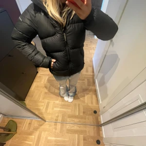 Svart dunjacka från Peak Performance - Säljer en svart dunjacka från Peak Performance i mycket bra skick nypris koster den 2000 kr. Jackan är perfekt för kalla vinterdagar och har en skön passform med dragkedja och huva. Den är långärmad och håller dig varm och bekväm. Perfekt för både vardag och utomhusaktiviteter! 