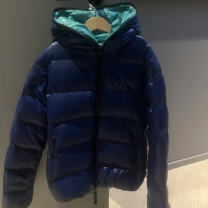 Duvetica dunjacka - Så varm och fin dunjacka från duvetica. Grön på insidan och blå på utsidan. Jättefint skick, inga defekter alls !! 