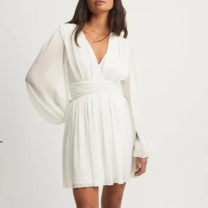 Student klänning - Säljer denna sjukt snygga vita klänningen från NA-KD. HELT OANVÄND, lappen är fortfarande på! Passar perfekt inför studenten. Säljer då jag hittade en annan klänning inför studenten. Tveka inte att skriva om du har frågor🫶🏼