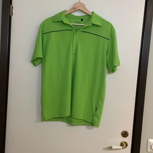 Grön kortärmad pikétröja från Feel - Säljer en fräsch grön pikétröja från Feel i storlek S. Tröjan har en klassisk krage med knappar och en stilren design med svarta detaljer. Perfekt för en avslappnad sommarstil eller en runda på golfbanan. 🏌️‍♂️Pris går alltid att förhandlas!