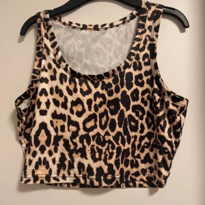 Leopardmönstrad croppad linnetopp - Säljer en supercool leopardmönstrad croppad linnetopp. Perfekt för en utekväll eller sommarens festivaler. Toppen är ärmlös och har en tight passform som framhäver figuren. Materialet är mjukt och stretchigt för extra komfort. 🐆✨Oanvänd